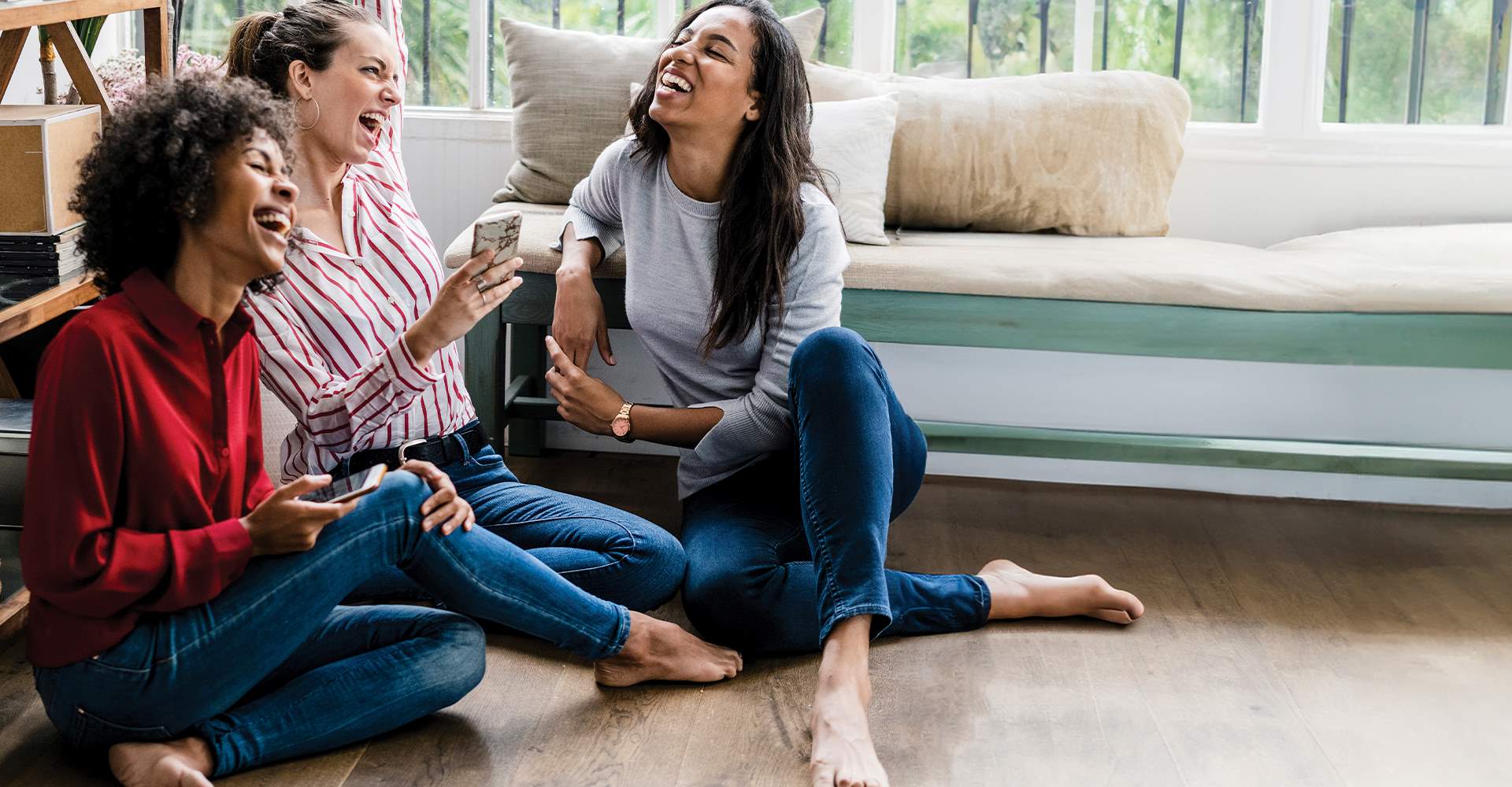 Friends in a living room with a light hardwood floor